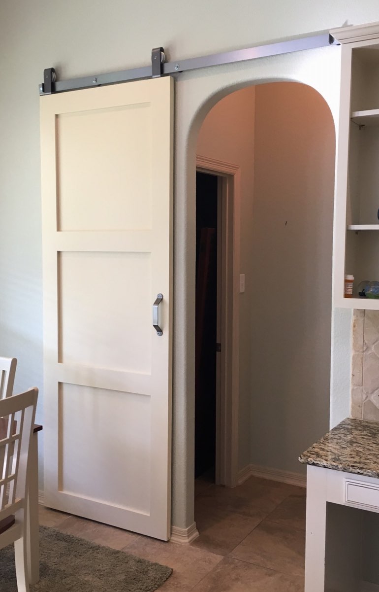 Sliding barn door on dark track used as bedroom door 